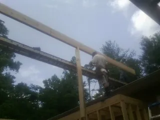 Carpenter setting a ridge beam over a new addition frame — Ice Dam Removal by Roofing Brothers in Manchester Township