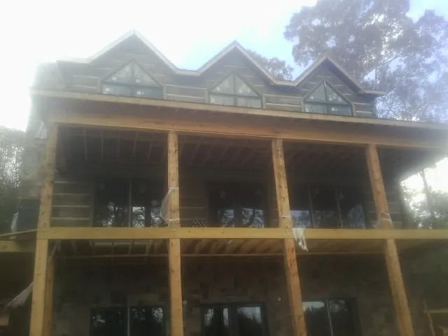 Dormers and porch framing on a large log home under construction — Roof Coating work by our crew in Manchester Township