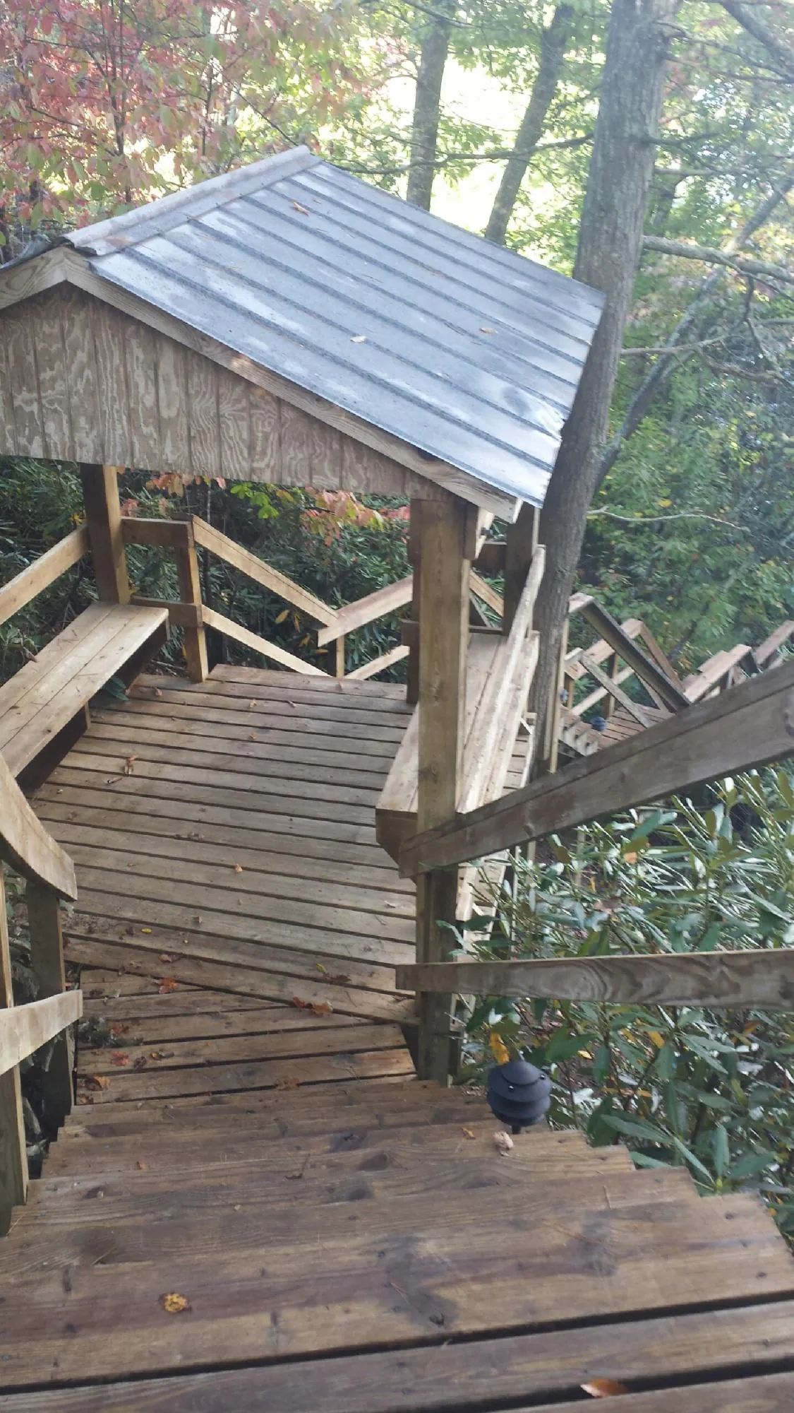 Metal roofed shelter over wooden steps on a wooded walkway — Skylight Repair & Installation work by our crew in Manchester Township