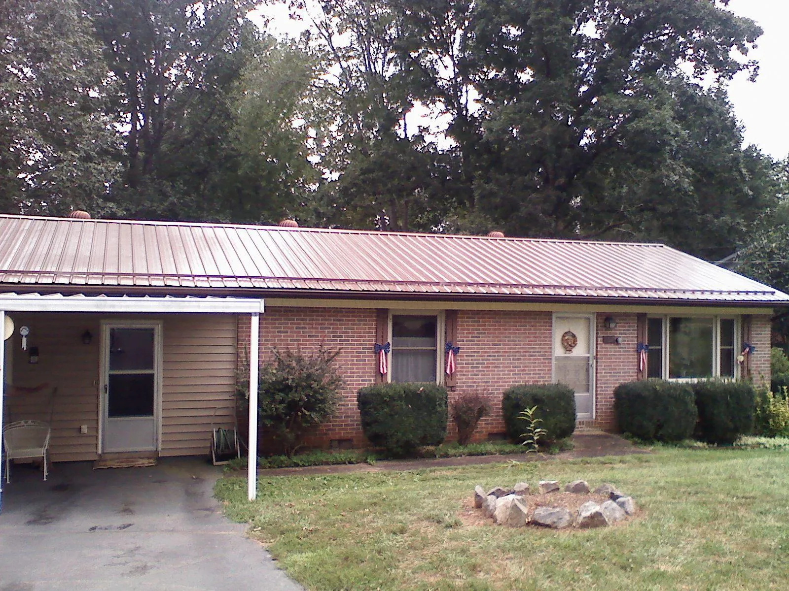 Bronze metal roof and carport on a brick ranch home — Roof Repair work by our crew in Manchester Township